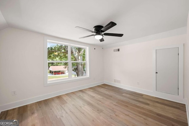 unfurnished room with ceiling fan, light wood-type flooring, and vaulted ceiling