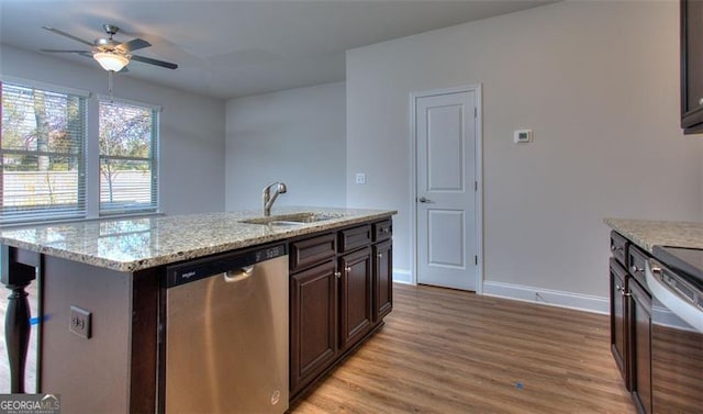 kitchen featuring ceiling fan, an island with sink, sink, stainless steel dishwasher, and light wood-type flooring