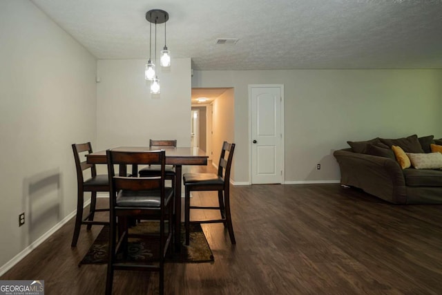 dining area featuring a textured ceiling and dark hardwood / wood-style flooring