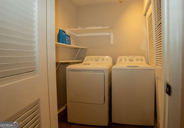 laundry area featuring dark hardwood / wood-style floors and washer and dryer