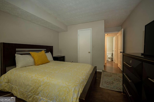 bedroom with a textured ceiling and dark wood-type flooring