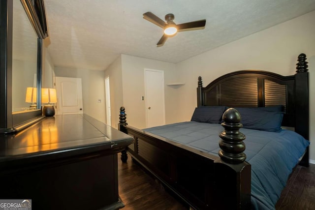 bedroom featuring a textured ceiling, ceiling fan, and dark wood-type flooring