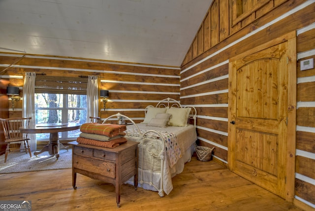 bedroom featuring light wood-type flooring and vaulted ceiling