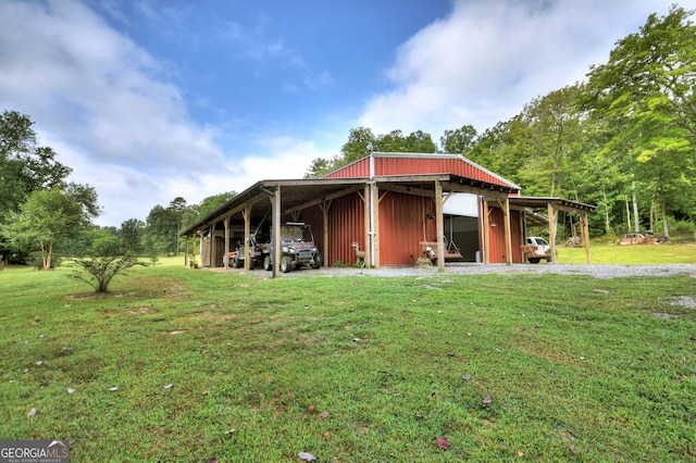 exterior space with an outbuilding, a lawn, and a carport