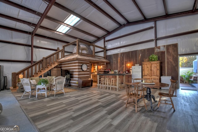 dining room with wood-type flooring and high vaulted ceiling