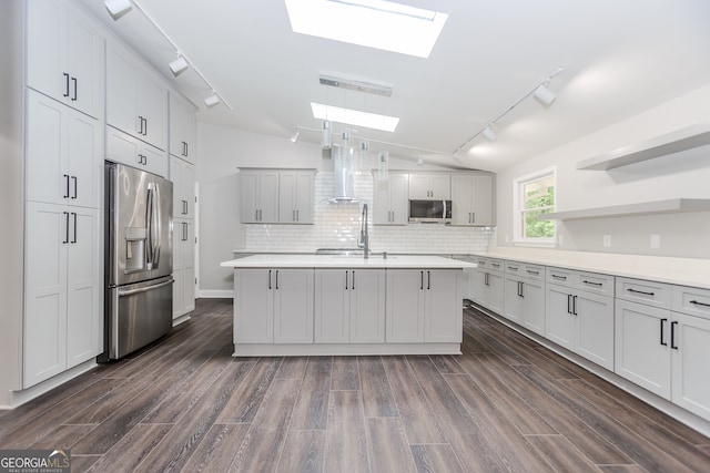 kitchen with dark wood-type flooring, appliances with stainless steel finishes, and lofted ceiling with skylight