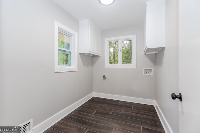 laundry room with washer hookup, dark hardwood / wood-style floors, and cabinets