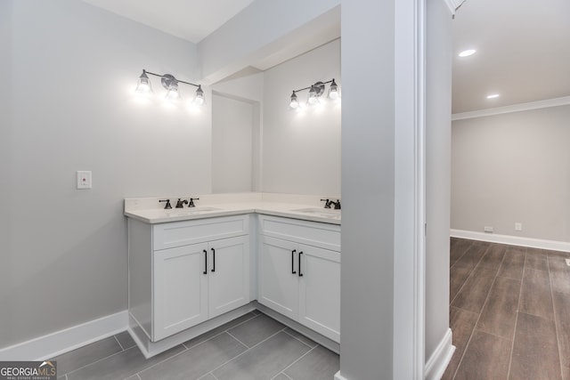 bathroom featuring hardwood / wood-style floors, crown molding, and vanity