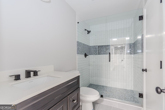 bathroom with vanity, toilet, a shower with shower door, and tile patterned flooring