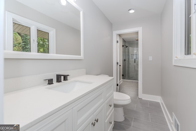 bathroom with tile patterned flooring, toilet, a shower with door, and vanity