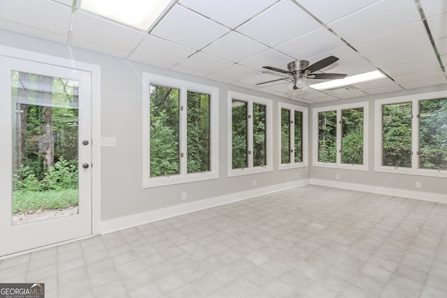 unfurnished sunroom with ceiling fan and a drop ceiling