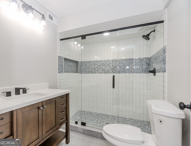 bathroom featuring vanity, toilet, tile patterned floors, and a shower with door