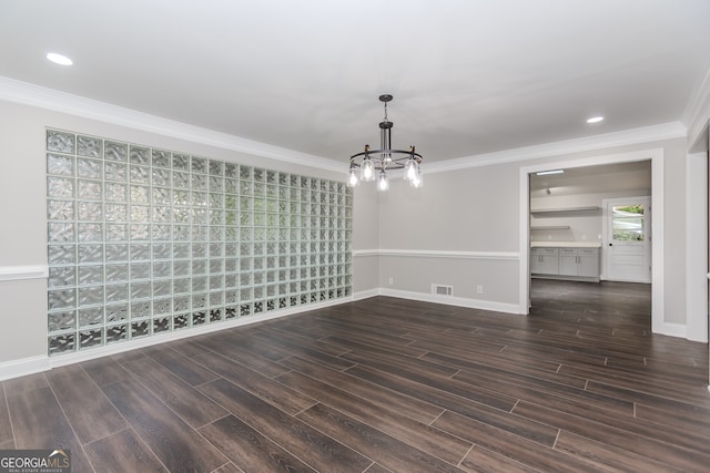 empty room with crown molding, dark wood-type flooring, and a notable chandelier