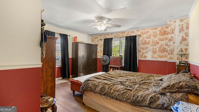 bedroom featuring ceiling fan, ornamental molding, and hardwood / wood-style floors