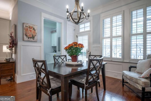 dining room with wood-type flooring, washing machine and clothes dryer, and a healthy amount of sunlight