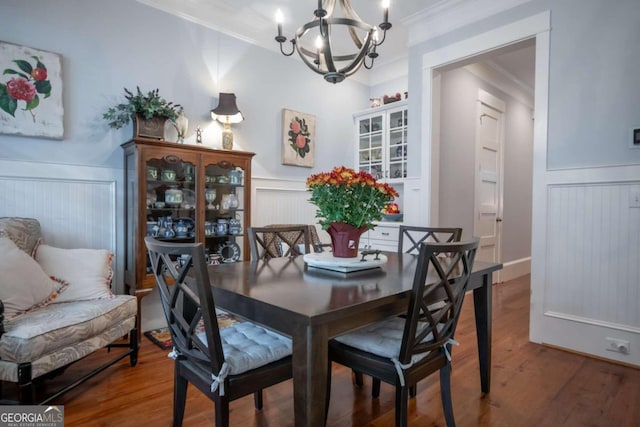 dining area featuring ornamental molding, a notable chandelier, and wood-type flooring