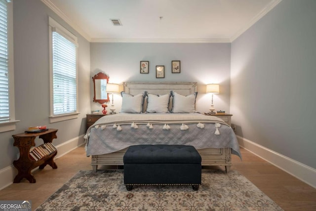 bedroom featuring crown molding and light hardwood / wood-style flooring