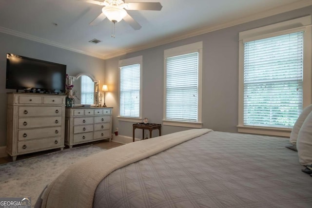 bedroom featuring ceiling fan, light colored carpet, and ornamental molding