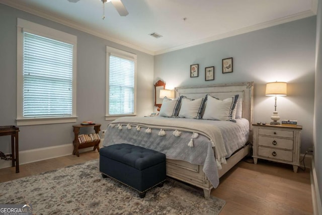 bedroom with crown molding, ceiling fan, hardwood / wood-style floors, and multiple windows