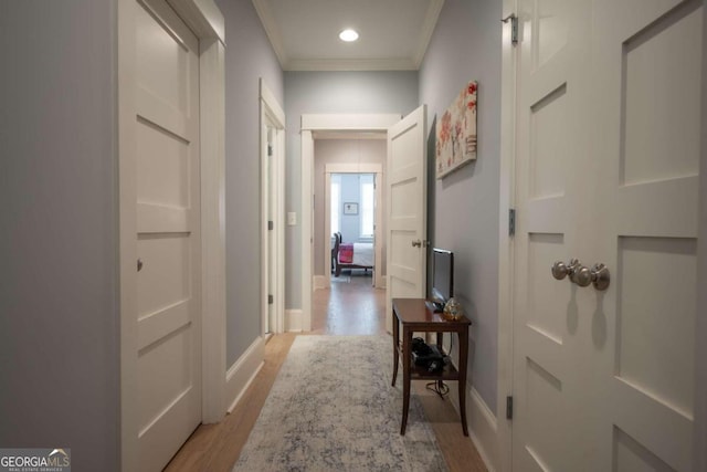 hall featuring ornamental molding and light hardwood / wood-style floors