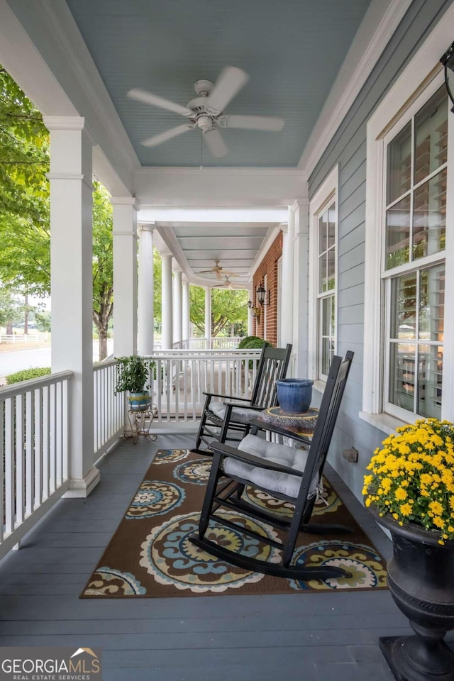 wooden deck featuring a porch and ceiling fan