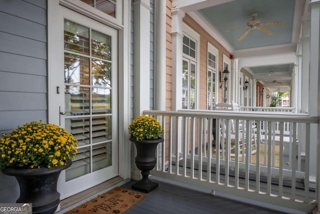 view of exterior entry featuring ceiling fan and covered porch