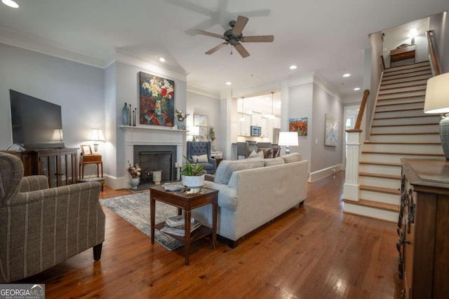 living room with ornamental molding, hardwood / wood-style floors, and ceiling fan