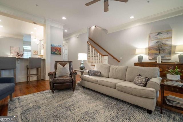 living room with crown molding, dark wood-type flooring, and ceiling fan