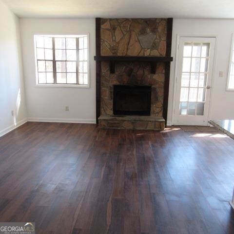 unfurnished living room with dark hardwood / wood-style flooring and a fireplace