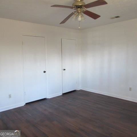 unfurnished bedroom with dark hardwood / wood-style flooring and ceiling fan