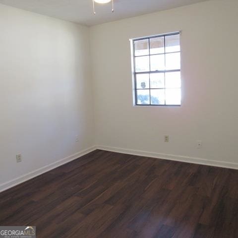 empty room featuring ceiling fan and dark hardwood / wood-style flooring