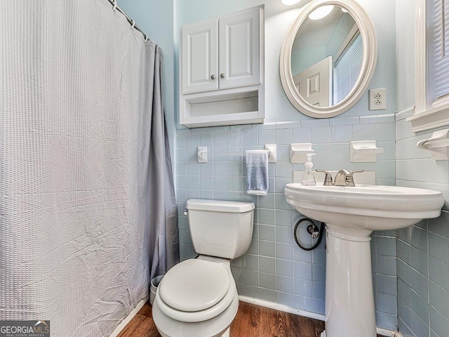 bathroom featuring wood-type flooring, walk in shower, tile walls, and toilet