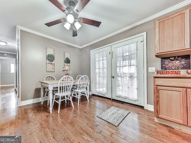 dining area featuring light wood-type flooring, crown molding, and ceiling fan