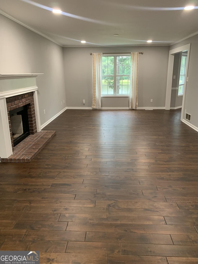 unfurnished living room featuring a fireplace, ornamental molding, and dark wood-type flooring