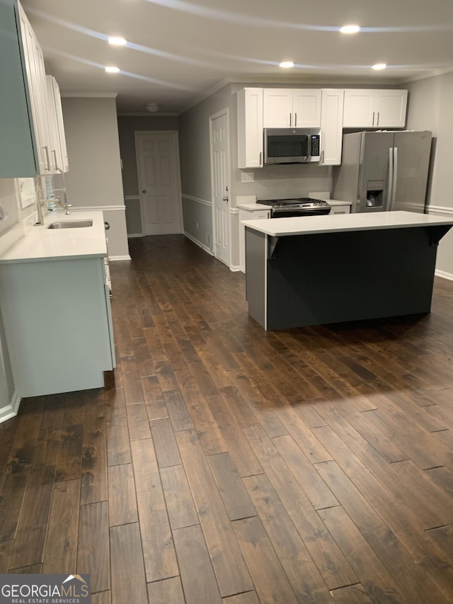 kitchen with a center island, white cabinets, dark hardwood / wood-style floors, and appliances with stainless steel finishes