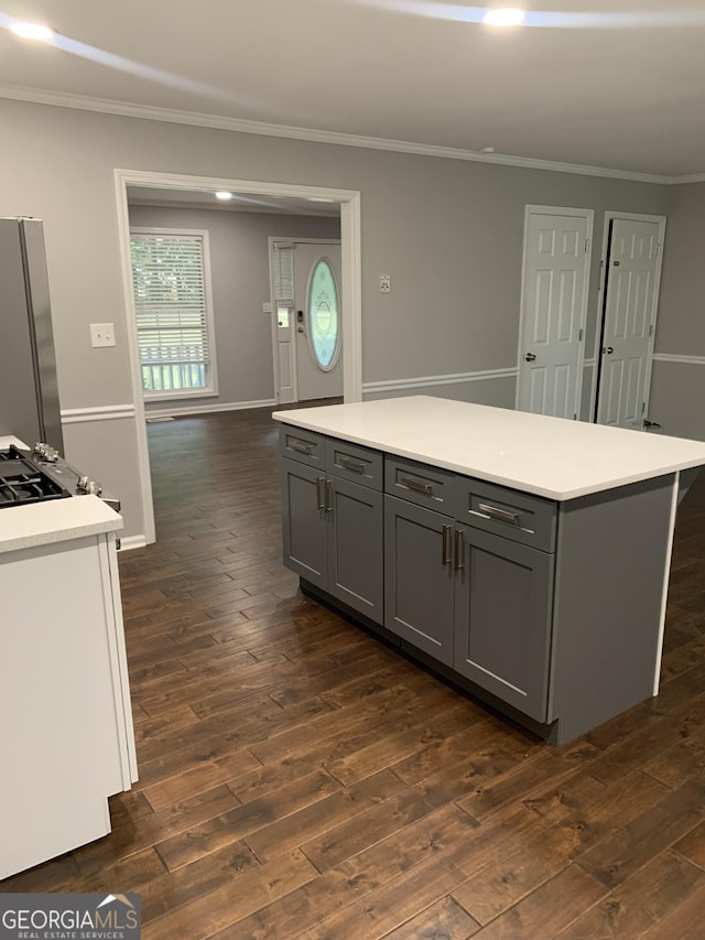 kitchen with stainless steel fridge, dark hardwood / wood-style floors, ornamental molding, and gray cabinetry