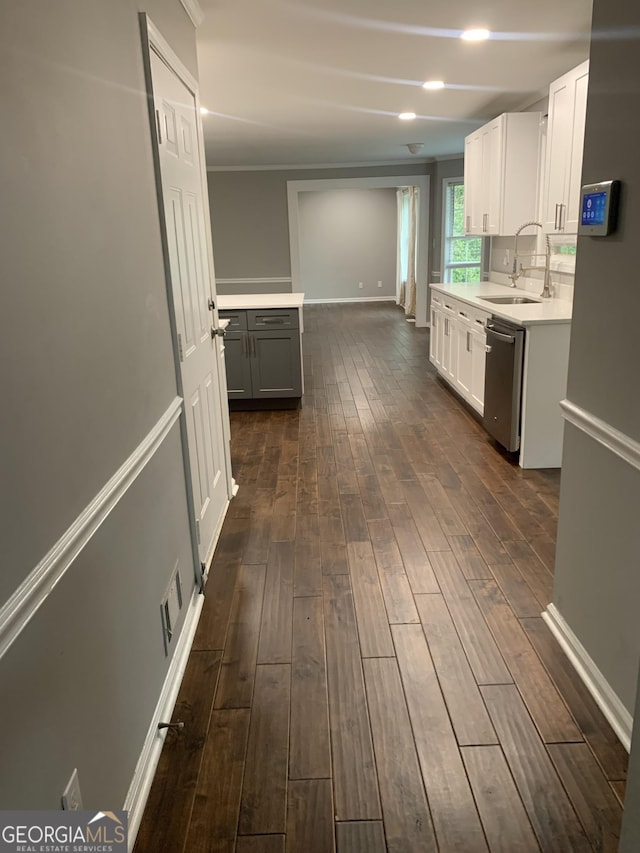 kitchen with dishwasher, white cabinets, sink, crown molding, and dark hardwood / wood-style flooring