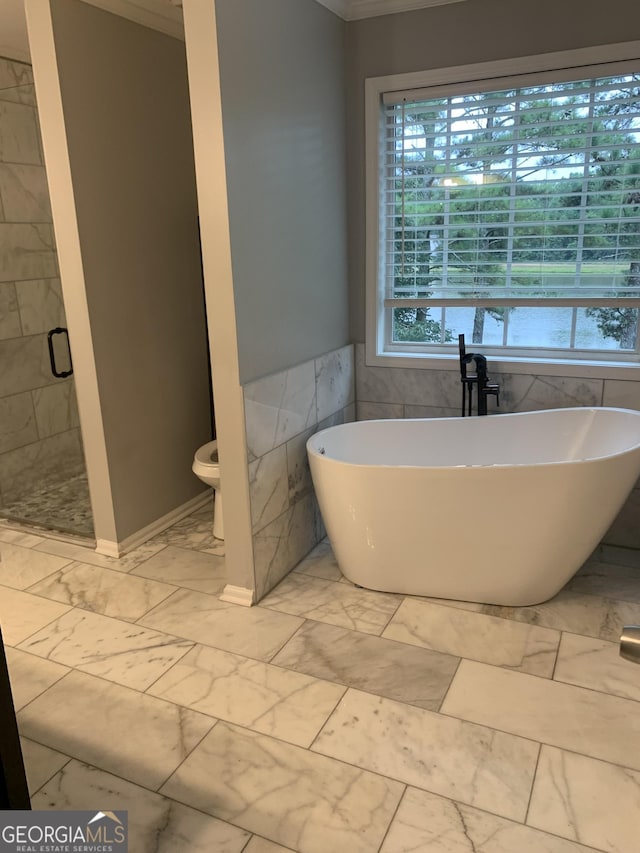 bathroom featuring toilet, separate shower and tub, tile walls, and crown molding