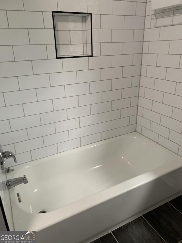 bathroom featuring tile patterned floors and tiled shower / bath