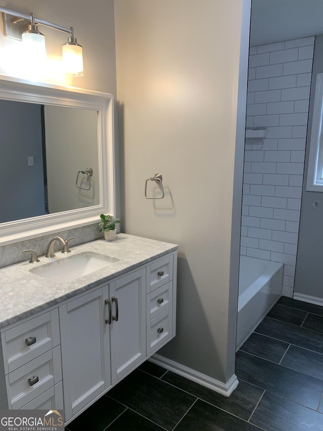 bathroom featuring vanity and tiled shower / bath