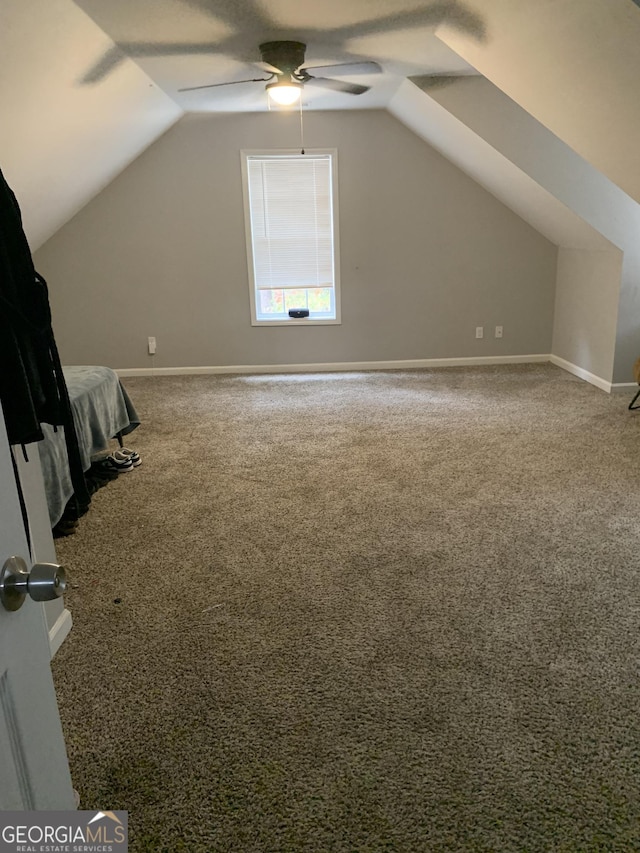 additional living space featuring carpet, vaulted ceiling, and ceiling fan