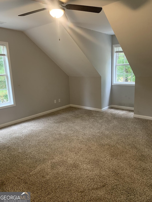 additional living space featuring carpet flooring, plenty of natural light, ceiling fan, and vaulted ceiling