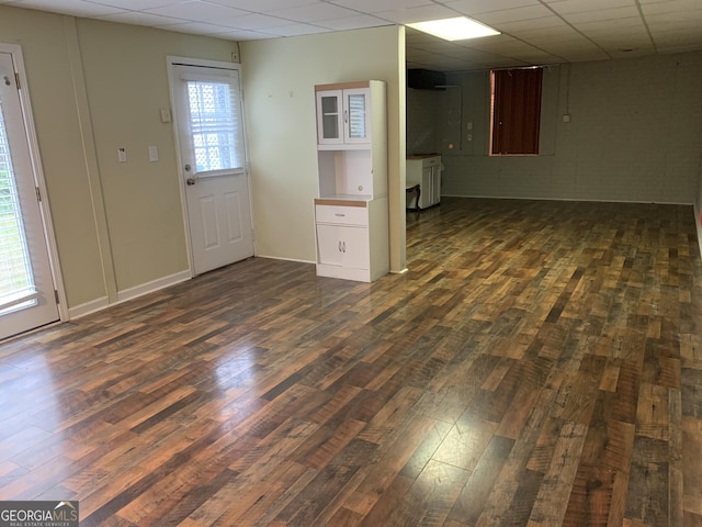 interior space featuring dark hardwood / wood-style floors, a drop ceiling, and a wealth of natural light