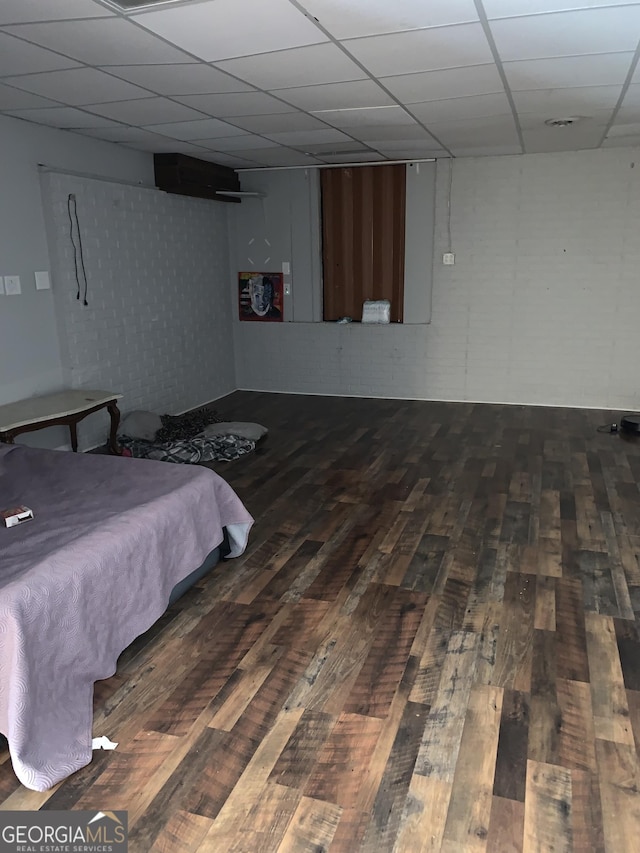 bedroom featuring a paneled ceiling and dark hardwood / wood-style flooring