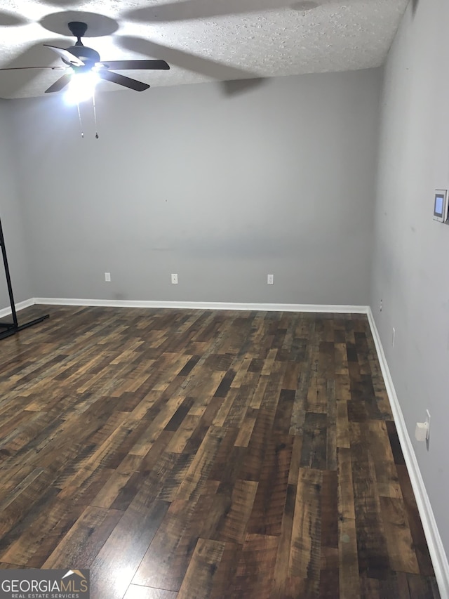 spare room featuring ceiling fan, dark hardwood / wood-style flooring, and a textured ceiling