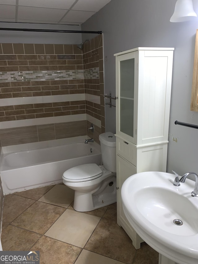 full bathroom with a drop ceiling, toilet, sink, and shower / washtub combination