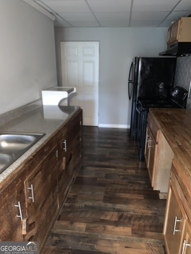 kitchen featuring a drop ceiling, sink, electric range, dark hardwood / wood-style floors, and extractor fan