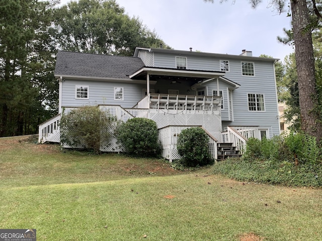 rear view of property with a yard and a deck