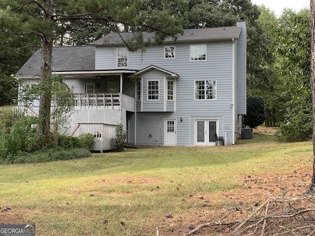 back of house with a yard, a wooden deck, and central air condition unit