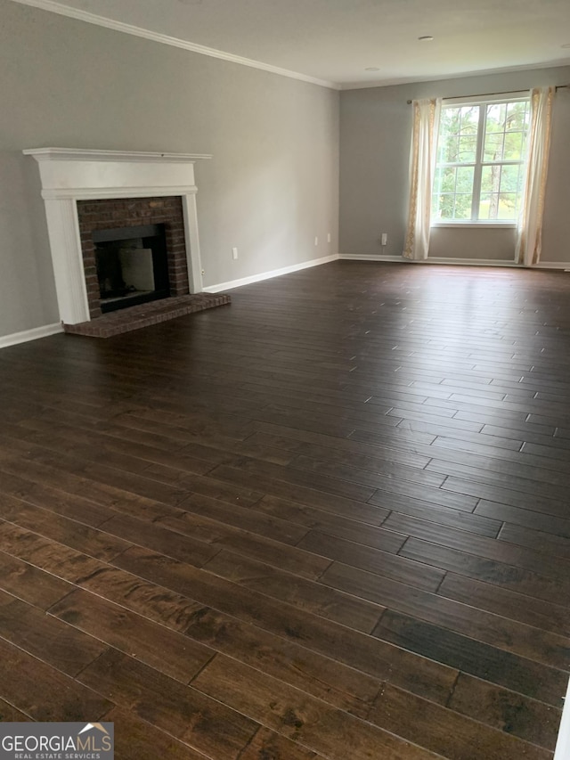 unfurnished living room featuring a fireplace, dark hardwood / wood-style flooring, and crown molding